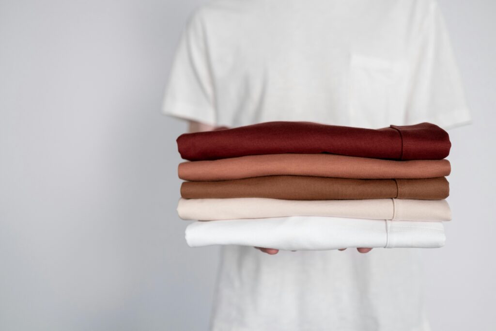 Person holding a pile of freshly clean and folded clothes