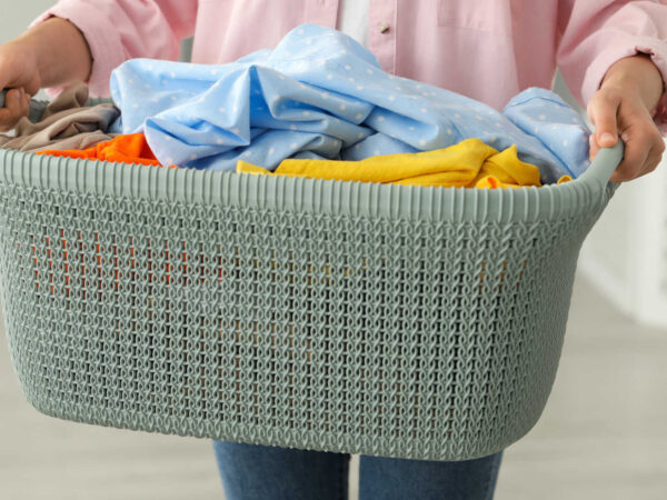 Fabric washing guide – Woman holding a basket of clean laundry