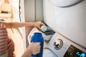 Woman pouring the right laundry detergent in the washing machine