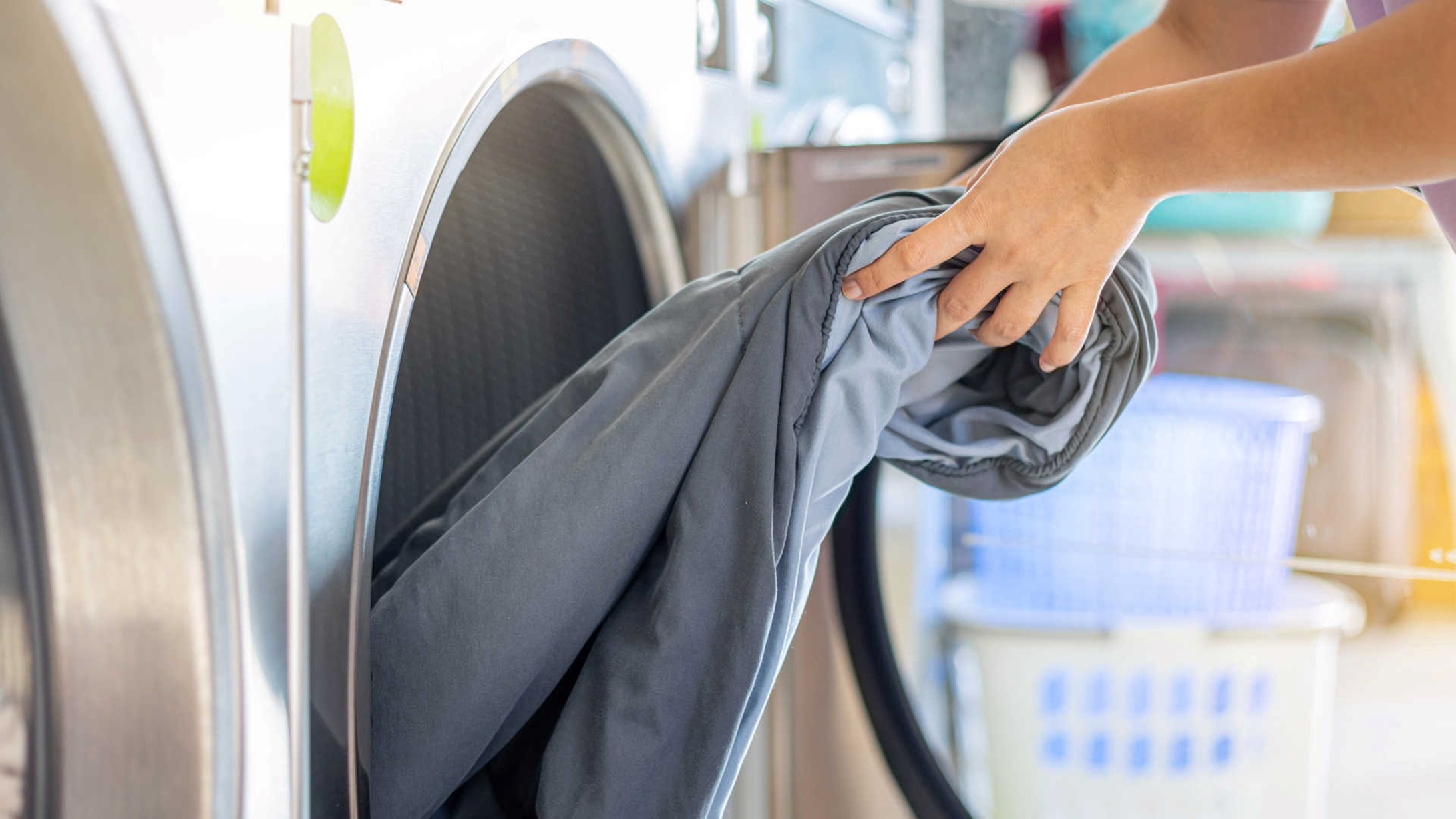Laundromat myths – woman taking clothes out of commercial washing machine