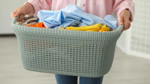 Fabric washing guide – Woman holding a basket of clean laundry