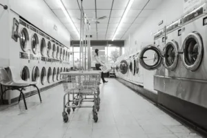 black & white Image of a quiet laundromat with one women doing her washing