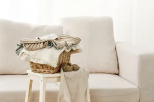 Basket with folded fresh clean clothes above the chair