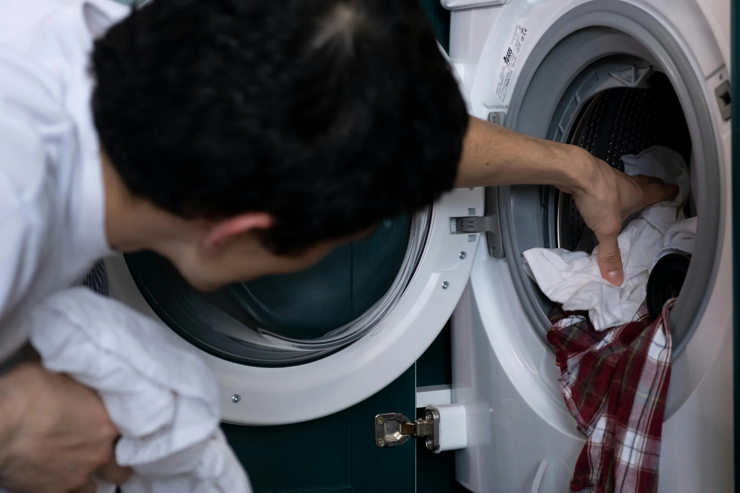 Man getting laundry from washing machine