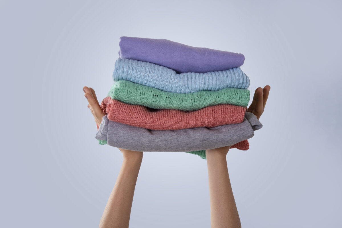 hand holding folded clothes washed with laundry hacks